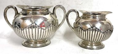 A Victorian silver twin handled sugar bowl and matching cream jug of oval form, the body with part