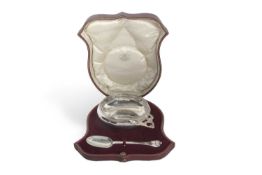 A George V cased porringer of polished circular form with pierced lug handle and trefid spoon, the