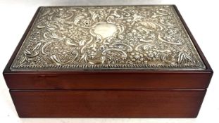 Modern silver topped jewellery box embossed with scrolls, flowers etc around a plain cartouche,