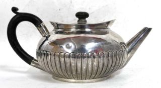 A Victorian silver teapot of squat circular form having a half fluted body, ebonised finial and