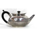 A Victorian silver teapot of squat circular form having a half fluted body, ebonised finial and