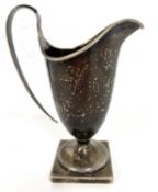 Hallmarked silver cream jug of helmet shape, the foot is a square pedestal form having a loop reeded