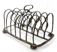 A George IV silver toast rack of oblong form supported on four bun feet of six divisions and a