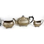 George V silver three piece tea set of oval form with applied gadrooned rims and supported on four