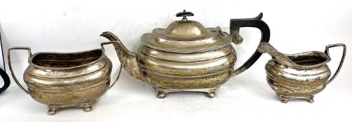 George V silver three piece tea set of oval form with applied gadrooned rims and supported on four