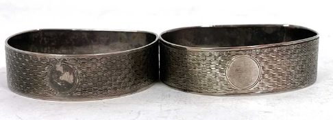 Two hallmarked silver D shaped serviette rings, engine turned decoration around a circular