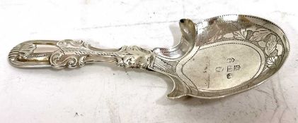 A George IV silver caddy spoon, fiddle and shell pattern, the shaped bowl chased and engraved with a