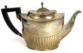 A hallmarked silver teapot of oval form, half fluted body and hinged urn finial lid, ebonised