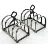 A pair of Art Deco small silver toast racks, each with four hoop divisions and having a trefoil