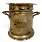 A George V silver twin handled bottle holder/coaster of typical form having presentation engraving