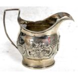 George III silver cream jug of oval form, the body decorated and embossed with foliage around an