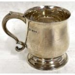 A George V small silver tankard of plain baluster form, looped handle and raised on a spreading