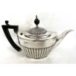Late Victorian silver teapot of oval form, the hinged lid with part fluted detail with ebonised