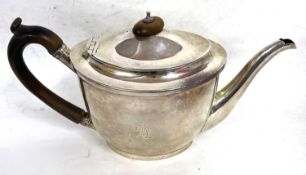 A George III silver teapot of oval form with hinged lid mounted with a turned wooden finial and