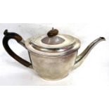 A George III silver teapot of oval form with hinged lid mounted with a turned wooden finial and