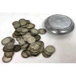 Seventy 3d silver pence coins, various dates, 99 gms, housed in a metal compact