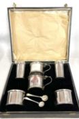 Cased matched silver condiments to include two hinged drum mustards, one with line, Chester 1935,