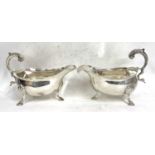 A pair of George III silver sauce boats of typical form with card cut rims, flying scroll capped