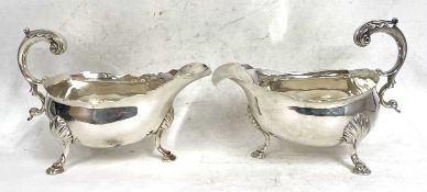 A pair of George III silver sauce boats of typical form with card cut rims, flying scroll capped