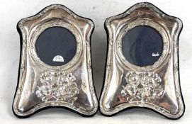 A pair of modern silver fronted photograph frames, decorated with cherubs, easel backed,
