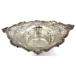 An Edwardian silver pierced basket of oval form, the rim applied with scrolls and masks and the body