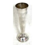 A hallmarked silver spill vase of plain tapering form with reeded detail (loaded), Sheffield 1954,