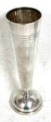 A hallmarked silver spill vase of plain tapering form with reeded detail (loaded), Sheffield 1954,