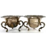 A pair of Edward VII open silver salts of cauldron form with serated edges, supported on three