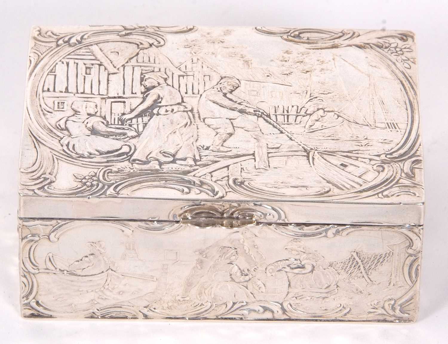 A Dutch white metal box of rectangular form, the lid and sides decorated with figures, boats, nets