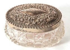 An Edwardian cut glass trinket box of oval form with hallmarked silver pull off embossed lid,