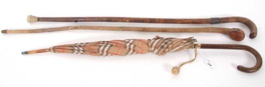 Mixed Lot: A Burberry umbrella, together with two vintage walking sticks (a/f)