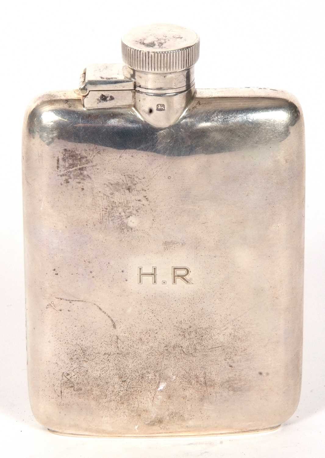 A spirit flask of plain slightly curved rectangular form engraved with initials "H.R" with hinged