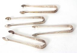 Four pairs of Georgian silver sugar tongs each with bright cut decoration, 140gms
