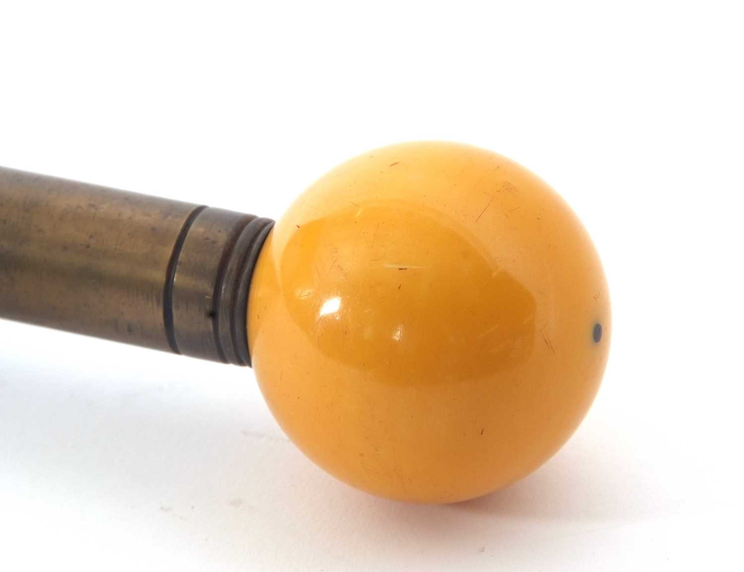 A vintage ebonised walking stick with an amber coloured resin ball finial - Image 2 of 4