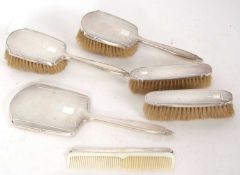 Art Deco silver backed dressing table items to include two hairbrushes, hand mirror, comb, two