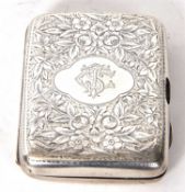 An Edwardian silver cigarette case, chased and engraved a monogrammed cartouche, Chester 1901,