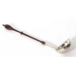 George II silver toddy ladle featurning a turned wooden handle and oval bowl with card cut rim and