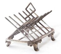 A Victorian silver toast rack of angular design with six divisions and on a stretcher base supported