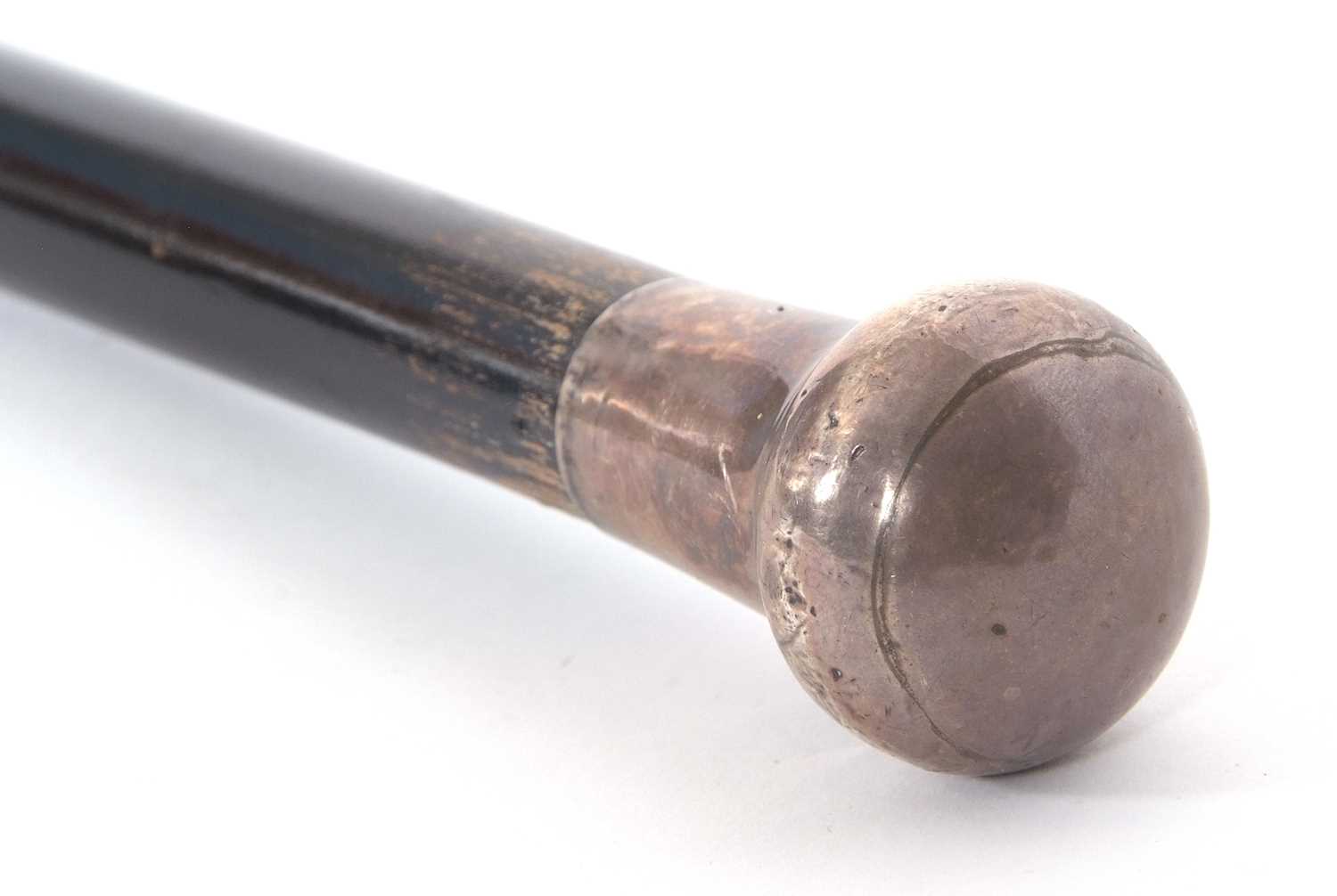 An early 20th Century black painted tapering cane, hallmarked silver handle for London 1920,
