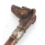 A vintage carved dog head walking stick, the head inset with glass eyes, articulated jaw opening his