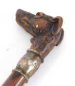 A vintage carved dog head walking stick, the head inset with glass eyes, articulated jaw opening his