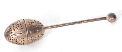 An Edwardian silver tea infuser with pierced egg shaped infuser, a plain handle and ball finial,