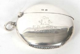An Edwardian silver vester of circular plain form with personalised engraving, Birmingham 1907,