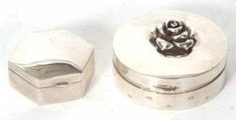 Two modern white metal pill boxes, a round shaped example, the lid applied with a bouquet of flowers