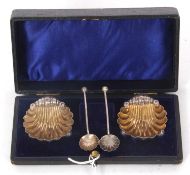 A chased pair of Victorian shell shaped salts on three ball feet and matching spoons, Birmingham
