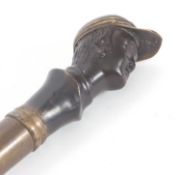 Vintage walking stick/cane with a weighted brass jockeys head on a later wooden shaft (a/f)