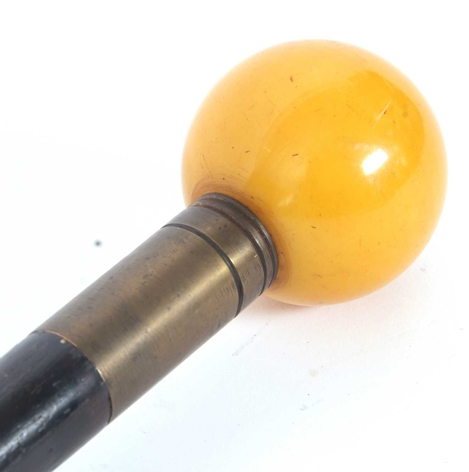 A vintage ebonised walking stick with an amber coloured resin ball finial - Image 4 of 4