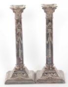 A pair of tall silver plated candlesticks by James Dixon & Sons with lift out drip pans, swagged