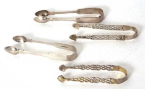 Four pairs of sugar tongs to include two Georgian pierced arm and shell bowl examples together