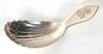 A George III Irish silver caddy spoon, oval shaped shell bowl and engraved with a figural crest,